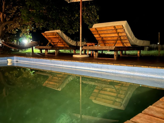 Tranquil night by the pool, with cozy loungers under a starlit sky. Relax and unwind.