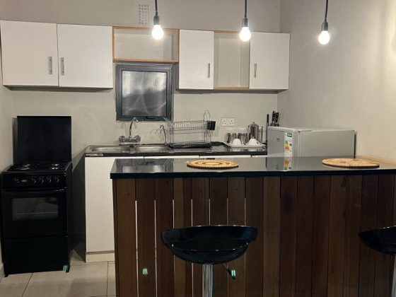 Modern kitchen with sleek finishes and cozy seating, perfect for culinary adventures.