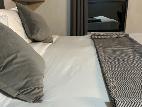 Cozy bedroom scene featuring plush pillows and a stylish patterned throw.