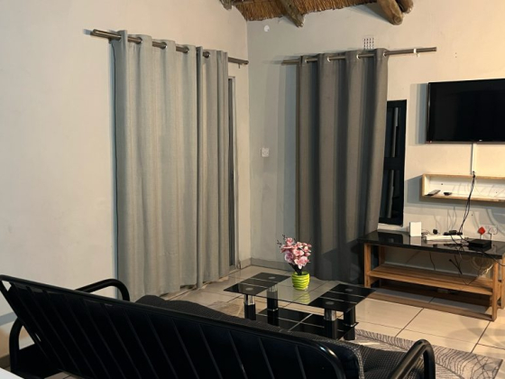 Cozy living space with muted decor, a TV, and a stylish coffee table. Perfect for relaxation.