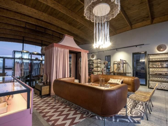 Chic clothing shop featuring stylish furniture and lighting.