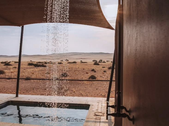 A serene view from an outdoor shower overlooking the desert.