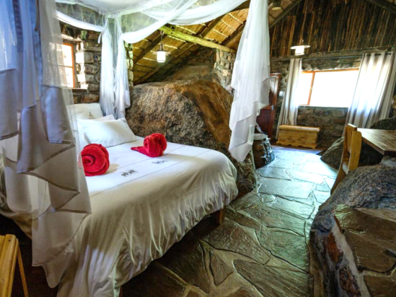 Inviting room featuring a bed and rock formations.