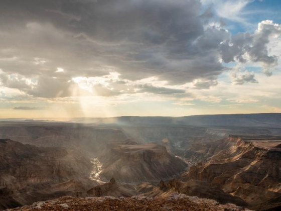 A breathtaking view of a canyon under cloudy skies.