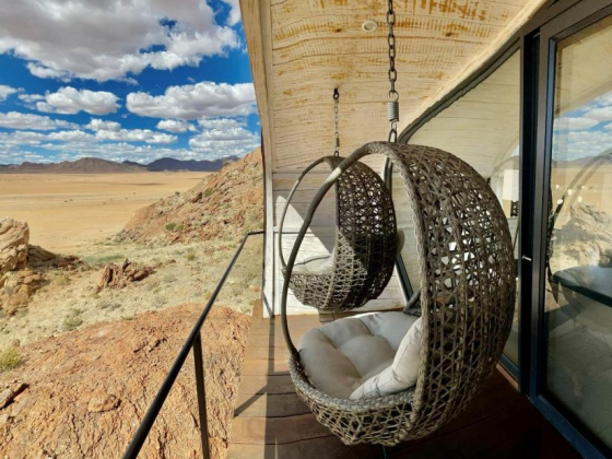 Stylish swings overlooking a vast desert landscape.