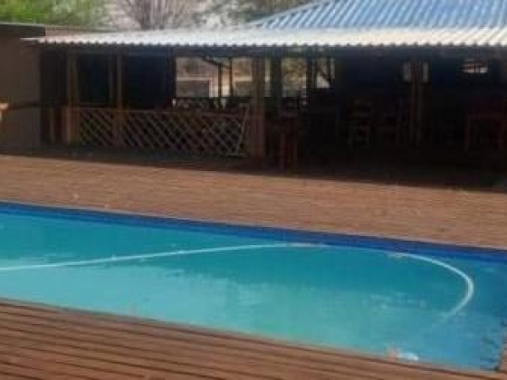 Serene oasis with a sleek pool and shaded deck, perfect for relaxation and gatherings.