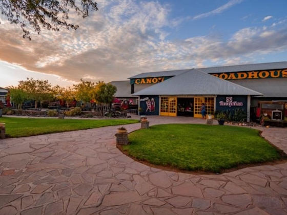 A roadhouse with a stone pathway and green lawn.