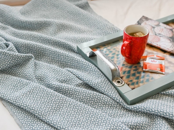 A comforting scene with a mug and snacks on a soft blanket.