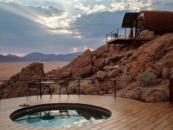 Cozy outdoor space with a hot tub and mountain backdrop.