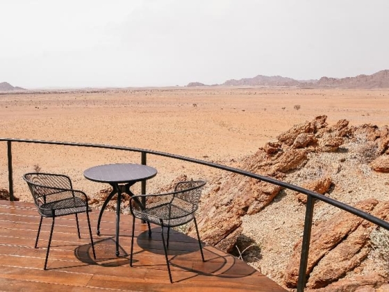 Serene desert landscape from a balcony seating area.